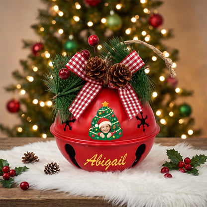 Personalized Christmas tree kid photo jingle bell ornament displayed on a tabletop