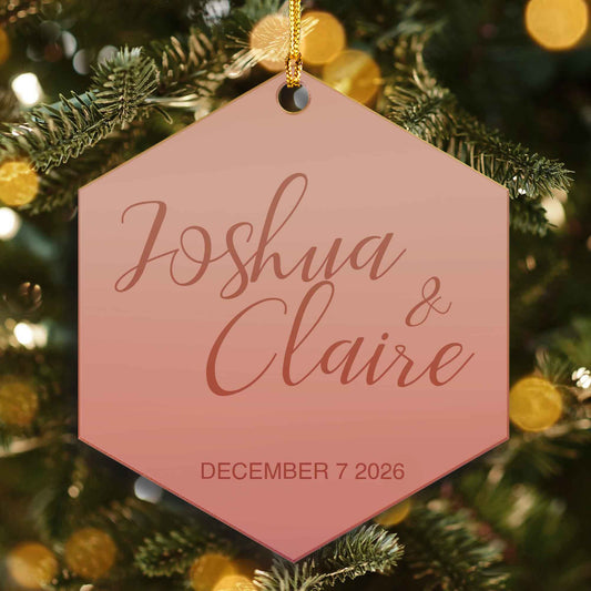 Rose gold mirrored hexagon ornament engraved with two names in script and a December 2026 wedding date