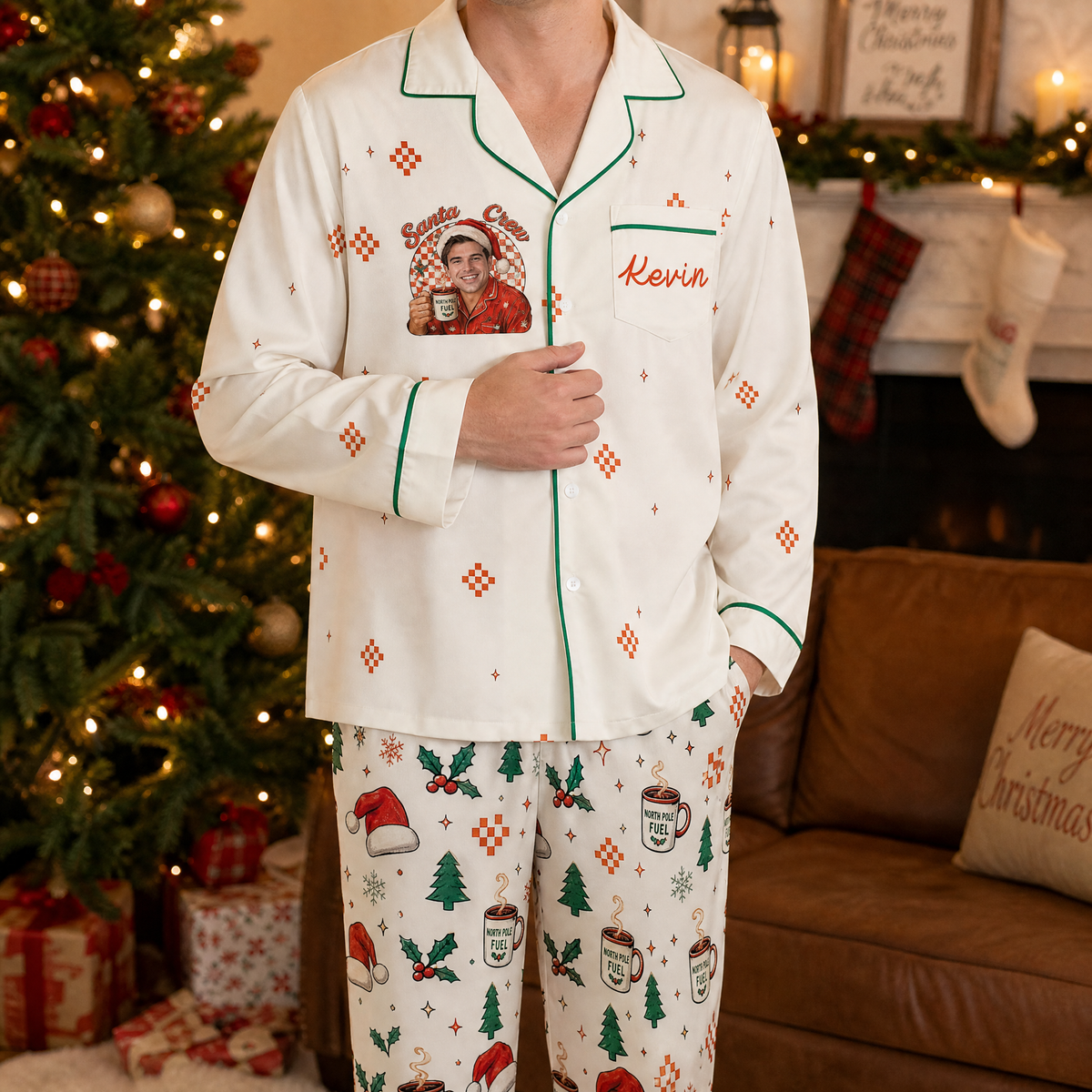 Man wearing custom face photo and name Santa crew cocoa mug Christmas pajamas by the tree
