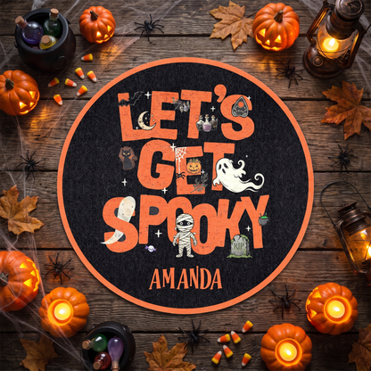 Personalized Halloween Let's Get Spooky Mummy Ghost Round Rug with custom name, styled on a wood floor with pumpkins