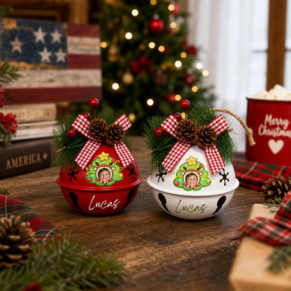 Two custom kid photo jingle bell ornaments displayed on a wooden table