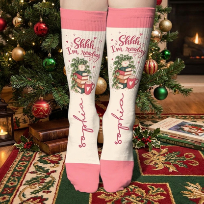 Personalized Shhh I'm Reading Christmas Socks worn on a cozy sofa by the Christmas tree