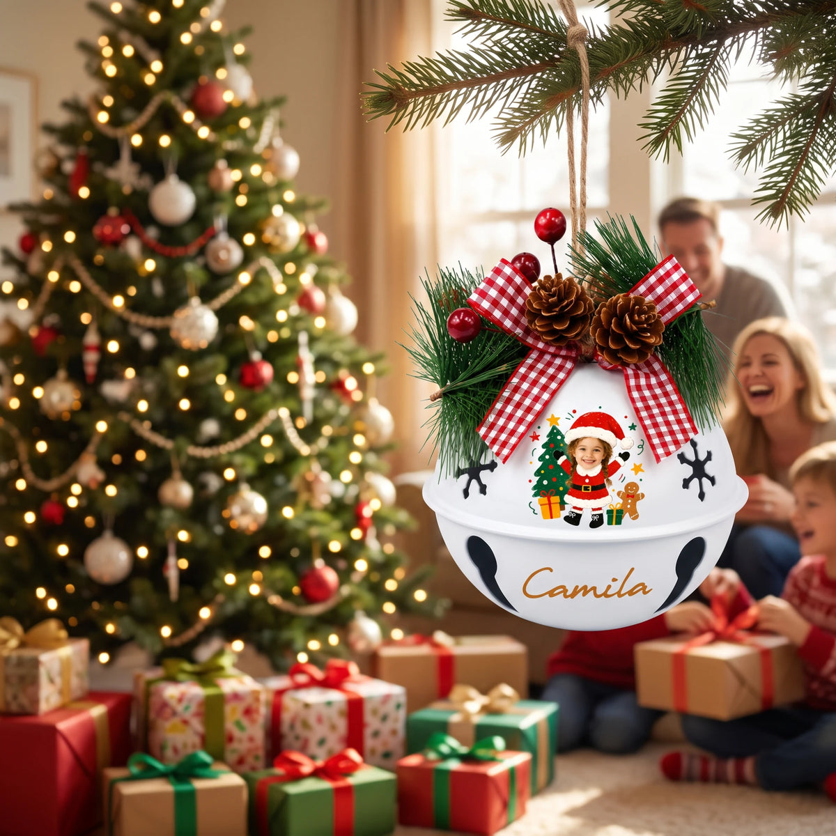 Personalized Santa kid jingle bell ornament hanging by the Christmas tree with family opening gifts